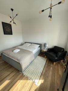 1 dormitorio con 1 cama y 1 silla en Apartament w centrum przy Studni 2 en Chełm