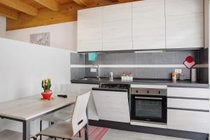 une cuisine avec des placards blancs et une table en bois dans l'établissement Agriturismo L'isola del Cavallo 4, à Desco