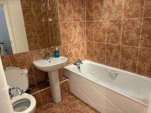 a bathroom with a sink and a tub and a toilet at Apartment In Birmingham City Centre in Birmingham