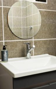 a bathroom sink with a mirror and a soap dispenser on it at Honolulu Lifestyle Guest Lodge in Burgersfort