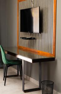 a desk with a television and a green chair at Honolulu Lifestyle Guest Lodge in Burgersfort