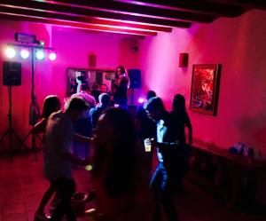 un gruppo di persone che ballano in una stanza con luci rosa di Country House Etna Glicine a Piedimonte Etneo