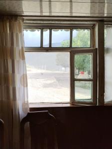 an open window with a view of a field at Xinaliq Qonaq Evi in Xınalıq