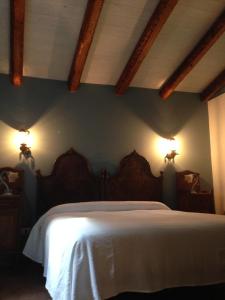 een slaapkamer met een bed met twee lampjes aan de muur bij Country House Etna Glicine in Piedimonte Etneo