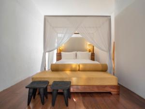 a bedroom with a bed with a canopy and two tables at KA BRU Beach Boutique Hotel in Barra Grande +158 photos