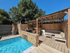 une arrière-cour avec une piscine et une terrasse en bois dans l'établissement Villa Standing Villelongue de la Salanque 66410, à Villelongue-de-la-Salanque