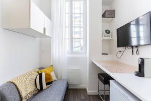 een woonkamer met een bank en een keuken met een aanrecht bij Lavie Maison Bordeaux Bliss Studio in Bordeaux