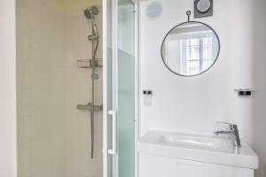 een witte badkamer met een wastafel en een spiegel bij Lavie Maison Bordeaux Bliss Studio in Bordeaux