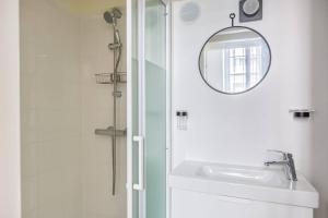 biała łazienka z umywalką i lustrem w obiekcie Lavie Maison Bordeaux Bliss Studio w mieście Bordeaux
