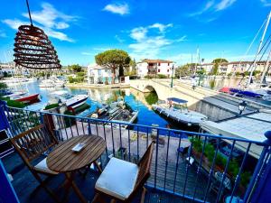 a balcony with a table and chairs next to a marina at Pura Vida, Port Grimaud in Grimaud