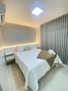 Un dormitorio con una gran cama blanca y una ventana en Luxuoso 2Q St Bueno - 3101, en Goiânia