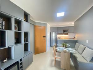 uma cozinha e sala de estar com uma mesa e um sofá em Luxuoso 2Q St Bueno - 3101 em Goiânia