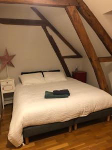 1 dormitorio con cama blanca y vigas de madera en LE GITE LACHELLE, en Lachelle