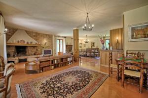a large living room with a table and a fireplace at Villa Lauretana by PosarelliVillas in Torrita di Siena