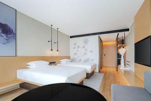 a hotel room with two beds and a tv at Fairfield by Marriott Beijing Daxing Airport in Beijing