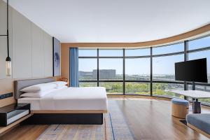 a hotel room with a bed and a large window at Fairfield by Marriott Beijing Daxing Airport in Beijing