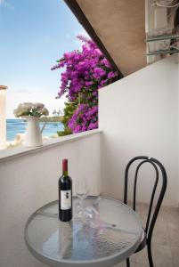 een glazen tafel met een fles wijn en een stoel bij Luna Tsuki Two in Rovinj