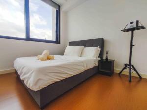 una camera da letto con un letto con un orsacchiotto sopra di 2BR 4 PAX - Cinema @ The Hub SS2 PJ 中文房东 a Petaling Jaya