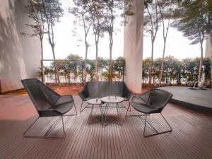 3 sedie e un tavolo su un patio alberato di 2BR 4 PAX - Cinema @ The Hub SS2 PJ 中文房东 a Petaling Jaya