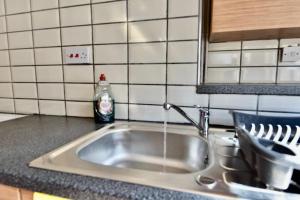 a kitchen sink with water running from a faucet at Come on in Lucas Street Newport Train Station Sleep upto 8 in Newport