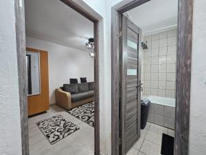 a bathroom with a door open to a living room at Cluj Zorilor Residence in Cluj-Napoca