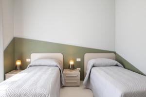 dos camas sentadas una al lado de la otra en un dormitorio en Viride Mare, en Numana