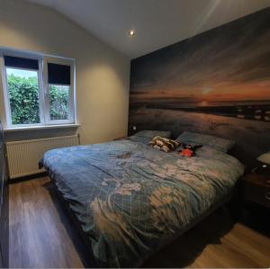 um quarto com uma cama com um quadro na parede em De Oase - Park de Horn 821 em Dirkshorn