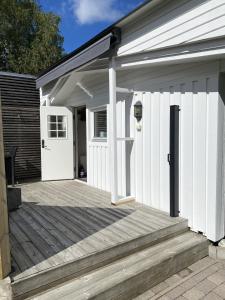 a white garage with a wooden deck at Studio 51 Örgryte in Gothenburg