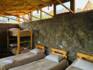 two bunk beds in a room with a stone wall at Green Camp eco-rural and civil society tourism center 