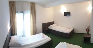 Habitación de hotel con 2 camas y TV en Hotel Lohovo, en Lohovo
