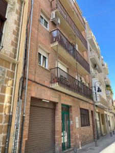 ein Backsteingebäude mit einer Garage und einem Balkon in der Unterkunft Apartamento Enriqueta in Granada