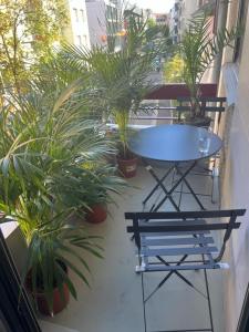 a table and chairs on a balcony with plants at Stylish 1-bedroom condo close to exhibition square in Basel