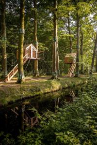 une petite maison au milieu d'une forêt dans l'établissement Treehouse 'Morgenrood' Ryckevelde 1451, à Damme