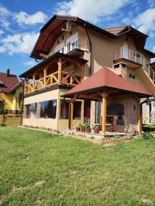 een groot huis met een grote veranda op een gazon bij Apartmani Šarović Tara 2 in Rača