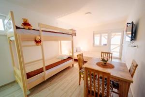 een kleine kamer met een stapelbed en een tafel bij Apartmani Šarović Tara 2 in Rača