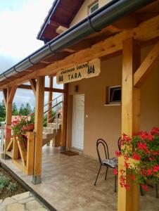 een portiek van een huis met een bord waarop staat immigratiepijl taza bij Apartmani Šarović Tara 2 in Rača