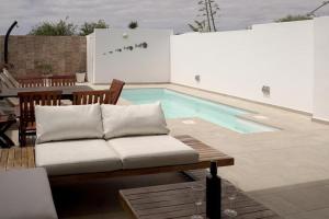 a couch sitting in front of a swimming pool at Casa Lily in Tías