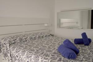 a bedroom with a bed with purple pillows and a mirror at Casa Lily in Tías +6 photos