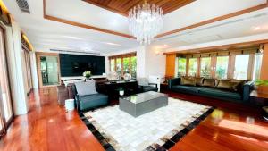 a living room with a couch and a chandelier at Yizen Beachfront Seaview Villa in North Pattaya
