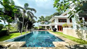a swimming pool in front of a house at Yizen Beachfront Seaview Villa in North Pattaya