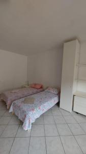 1 dormitorio con 2 camas y suelo de baldosa en Villesse Centro, 