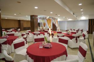 un salón de banquetes con mesas y sillas rojas y blancas en Four Points by Sheraton Vadodara, en Vadodara