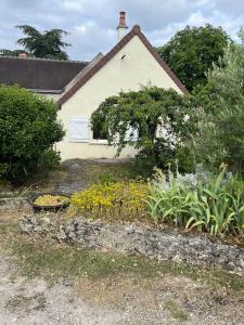 une maison avec un jardin fleuri devant elle dans l'établissement La petite maisonnette, à Saint-Georges-sur-Cher