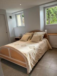 - un grand lit dans une chambre avec 2 fenêtres dans l'établissement La petite maisonnette, à Saint-Georges-sur-Cher