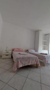 a white room with two beds and a table at Villesse Centro 
