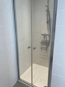 La salle de bains est pourvue d'une douche avec une porte en verre. dans l'établissement La petite maisonnette, à Saint-Georges-sur-Cher