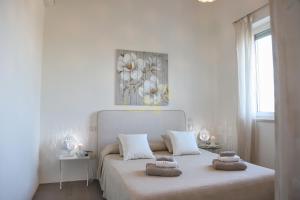 a white bedroom with a bed with two towels on it at Trulli&Dimore- Il Vecchio Fienile in Polignano a Mare