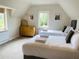 1 dormitorio con 2 camas, vestidor y 2 ventanas en Detached 4 bedroom home just 2km from Kenmare, en Kenmare