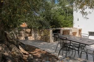a wooden table and chairs sitting under a tree at Trulli&Dimore- Il Vecchio Fienile in Polignano a Mare