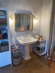 W łazience znajduje się umywalka i lustro. w obiekcie Ancien Presbytère de charme w mieście Thédirac